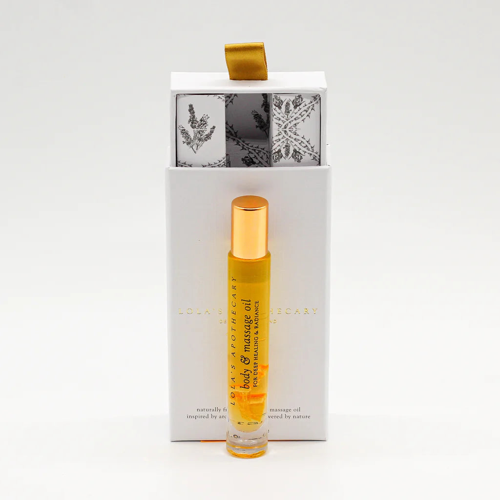 Roll-on bottle of "Euphoric Indulgence" perfume oil in front of a floral gift box