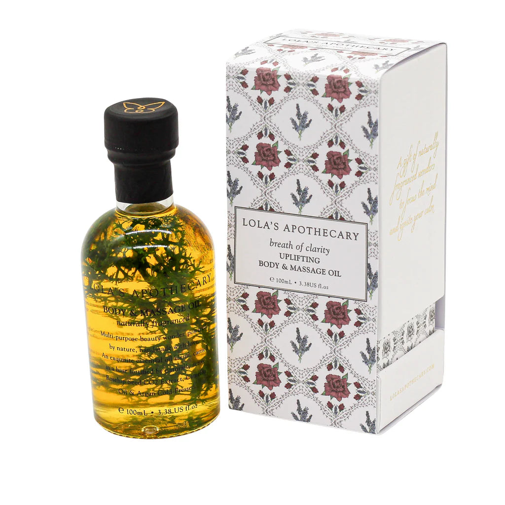 A bottle o "Breath of Clarity" body and massage oil next to floral gift box