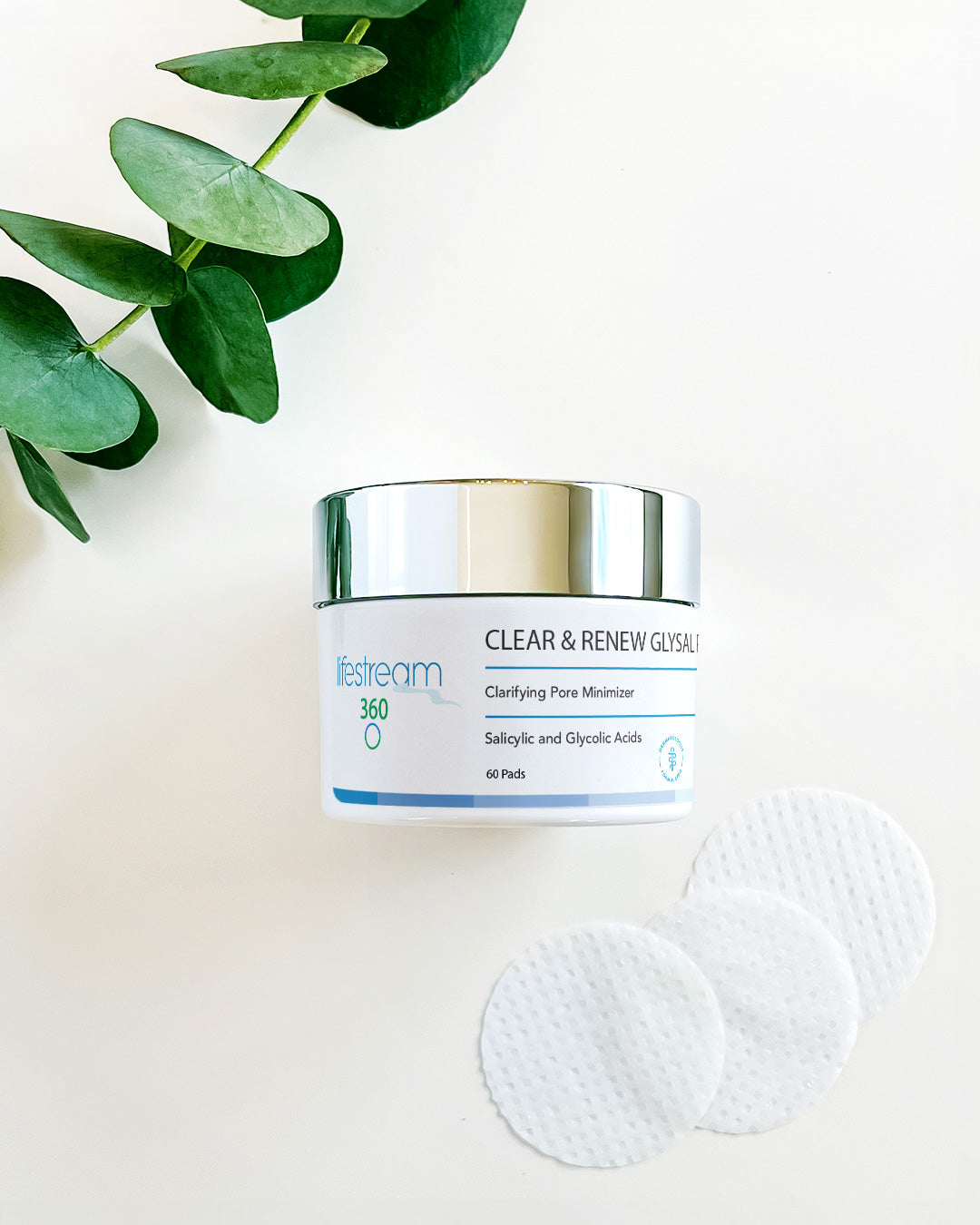 Jar of Clear & Renew Glysal Pads on a light background with eucalyptus leaves.