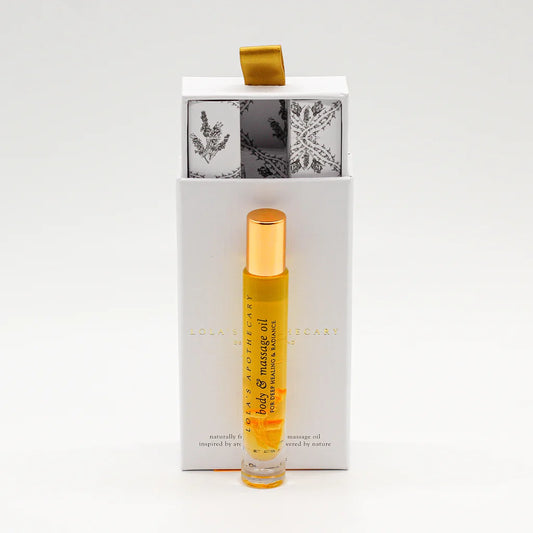 Roll-on bottle of "Euphoric Indulgence" perfume oil in front of a floral gift box 