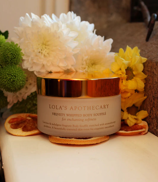 Jar of Euphoric Body Souffle cream with flowers nd orange slices
